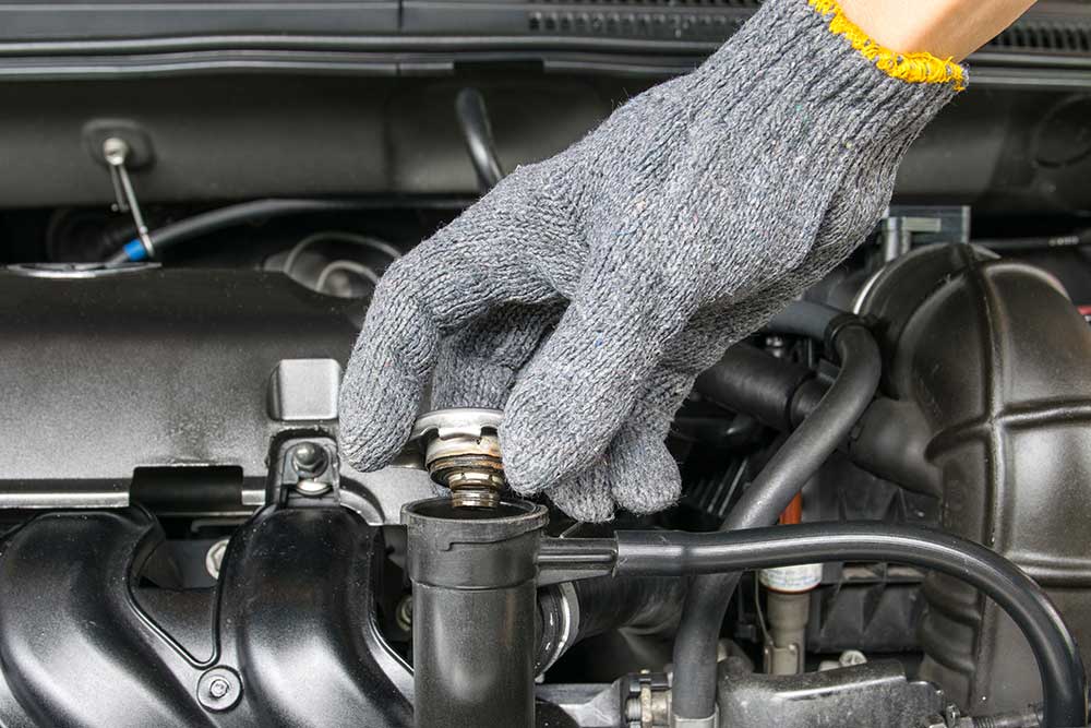 Hand doing a fluid check in the engine of a recreation vehicle as part of the RV inspection services we provide